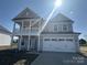 Charming two-story home with a welcoming front porch and attached two-car garage, bathed in sunlight at 3213 Mcharney Dr # 32, Harrisburg, NC 28075