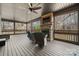 A large covered outdoor area featuring a stone fireplace, comfortable seating, and views of a wooded landscape at 406 Third Ne Ave, Conover, NC 28613
