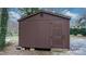 Exterior of a wooden storage shed with a simple door and surrounding gravel area at 406 Third Ne Ave, Conover, NC 28613