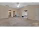 Large bedroom with carpet, windows, fan, and two entryways at 4504 Meridian Dr, Charlotte, NC 28216