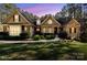 Charming brick home featuring manicured landscaping, symmetrical design, and warm exterior lighting at 4905 River Hills Dr, Denver, NC 28037