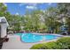 Community pool with lounge chairs and tables, surrounded by trees at 537 Southeast Dr # 537, Davidson, NC 28036