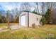 A large, standalone outbuilding with metal siding and a roll-up garage door, offering ample storage space at 6000 George Hildebran School Rd, Hickory, NC 28602