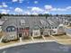 A row of colorful brick townhomes with well-kept lawns, and inviting curb appeal at 6814 Piper Thorn Way, Indian Land, SC 29707