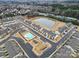A wide aerial showing a pond with fountain, community pool and clubhouse amidst neighborhood homes at 6814 Piper Thorn Way, Indian Land, SC 29707