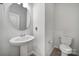 Neat half bathroom features pedestal sink, toilet, and updated lighting at 6814 Piper Thorn Way, Indian Land, SC 29707