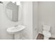 Powder room featuring a pedestal sink, new toilet, and wood grain flooring at 6814 Piper Thorn Way, Indian Land, SC 29707
