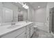 Bathroom featuring double sinks, a bathtub, a glass shower cabin, and white cabinetry at 6814 Piper Thorn Way, Indian Land, SC 29707