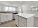 Modern white kitchen island with quartz countertops and stainless steel sink at 6814 Piper Thorn Way, Indian Land, SC 29707