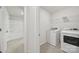 Bright laundry room featuring a washer, dryer, and a view into an adjacent bathroom with tiled floors at 6814 Piper Thorn Way, Indian Land, SC 29707