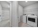 This modern laundry area includes newer appliances, storage shelving, and easy access to a bathroom at 6814 Piper Thorn Way, Indian Land, SC 29707