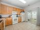 Bright kitchen featuring wooden cabinets, white appliances, and a sliding door to the patio at 706 Cherryfield Pl, Rock Hill, SC 29732