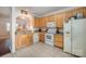Cozy kitchen featuring wood cabinets, white appliances and tile flooring at 706 Cherryfield Pl, Rock Hill, SC 29732