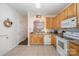 Charming kitchen with wooden cabinets, white appliances, and an open view to the dining area at 706 Cherryfield Pl, Rock Hill, SC 29732