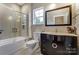 Stylish bathroom featuring a sleek vanity, modern mirror, and a tub-shower with glass enclosure at 7541 Thorn Creek Ln, Tega Cay, SC 29708