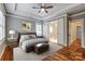 Main bedroom featuring a tray ceiling, fan, and access to the ensuite bathroom at 7541 Thorn Creek Ln, Tega Cay, SC 29708