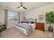 Cozy bedroom with a large window, ceiling fan, neutral colors, and a comfortable queen-sized bed at 810 Latrobe Dr, Iron Station, NC 28080