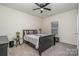 This bedroom is complete with a ceiling fan, a sleek black bed frame, and natural light from the window at 8651 Shadetree St, Huntersville, NC 28078
