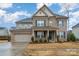 Charming two-story home with a brick and siding exterior, complemented by blue shutters and a well-manicured lawn at 8651 Shadetree St, Huntersville, NC 28078