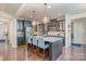 Modern kitchen with stainless steel appliances, granite countertops, kitchen island, and hardwood floors at 8651 Shadetree St, Huntersville, NC 28078