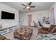 Cozy living area featuring a modern TV, brown couches, patterned ottoman and bright lighting at 8651 Shadetree St, Huntersville, NC 28078