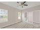 Bedroom with neutral walls, gray floors, and a door leading to the bathroom, plus two large windows at 8705 Moody Rd, Charlotte, NC 28215