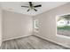 Bedroom with gray wood floors, neutral paint, a ceiling fan, and natural light from two large windows at 8705 Moody Rd, Charlotte, NC 28215