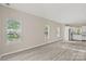 Open concept living room and kitchen area with gray flooring and lots of natural light through three large windows at 8705 Moody Rd, Charlotte, NC 28215