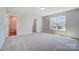 A well-lit bedroom with a carpet, large window, and access to a bathroom at 8720 Acadia Pkwy # 597, Sherrills Ford, NC 28673