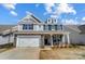 Charming two-story home with stone accents, shingle siding, white garage door, and manicured landscaping at 8720 Acadia Pkwy # 597, Sherrills Ford, NC 28673