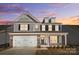 Charming two-story home with stone accents, shingle siding, white garage door, and manicured landscaping at 8720 Acadia Pkwy # 597, Sherrills Ford, NC 28673