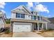 Charming two-story home with stone accents, shingle siding, white garage door, and manicured landscaping at 8720 Acadia Pkwy # 597, Sherrills Ford, NC 28673