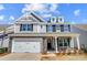 Charming two-story home with stone accents, shingle siding, white garage door, and manicured landscaping at 8720 Acadia Pkwy # 597, Sherrills Ford, NC 28673