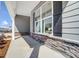 Inviting front porch featuring stone accents, gray siding, large windows with dark shutters, and a concrete walkway at 8720 Acadia Pkwy # 597, Sherrills Ford, NC 28673