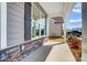 Inviting front porch featuring stone accents, gray siding, large windows with dark shutters, and a concrete walkway at 8720 Acadia Pkwy # 597, Sherrills Ford, NC 28673