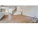 Open-concept living space with wood floors, staircase, white walls, and flowing into the kitchen at 8720 Acadia Pkwy # 597, Sherrills Ford, NC 28673