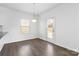 Dining area featuring hardwood floors, a modern light fixture, and a glass door to the exterior at 9022 Colwick Hill Ln, Charlotte, NC 28215