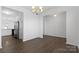 Open-concept dining area with wood floors, a modern chandelier, and ample natural light at 9022 Colwick Hill Ln, Charlotte, NC 28215