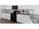 Well-equipped kitchen with granite countertops, white cabinets, and modern black appliances at 9022 Colwick Hill Ln, Charlotte, NC 28215