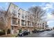 Long view of a row of modern townhomes with brick and light-colored siding and wrought iron balconies at 946 E 8Th St, Charlotte, NC 28204