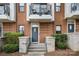Close up of townhome brick front entrance with concrete steps and a small wrought iron balcony above at 946 E 8Th St, Charlotte, NC 28204