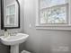 Bathroom sink with faucet and mirror with a window view with white walls at 9743 Aegean Ct, Huntersville, NC 28078