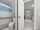 Bathroom view from doorway shows a toilet and shower with blue patterned curtain leading to the bedroom at 9743 Aegean Ct, Huntersville, NC 28078