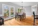 Sunlit dining area with hardwood floors, a chandelier, and multiple windows overlooking the backyard at 9743 Aegean Ct, Huntersville, NC 28078