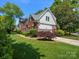 Side view of the beautiful home featuring a lush lawn and basketball hoop by the driveway at 9743 Aegean Ct, Huntersville, NC 28078