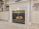Elegant fireplace featuring marble surround and decorative molding, flanked by built-in cabinets at 9743 Aegean Ct, Huntersville, NC 28078