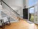Grand foyer featuring a staircase with black railings and a flood of natural light through large windows at 9743 Aegean Ct, Huntersville, NC 28078