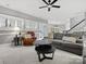 Bright living room features a ceiling fan, gray sofa, and a comfortable leather chair at 9743 Aegean Ct, Huntersville, NC 28078