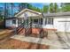 Charming front porch with brick stairs, leading to a green door and a relaxing seating area at 113 Tanager Dr, York, SC 29745