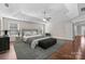 Staged primary bedroom with hardwood floors, a tray ceiling, and natural light at 12515 Hashanli Pl, Matthews, NC 28105